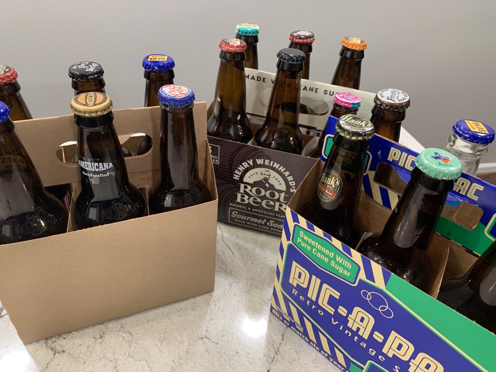 Three 6-packs with a variety of root beers